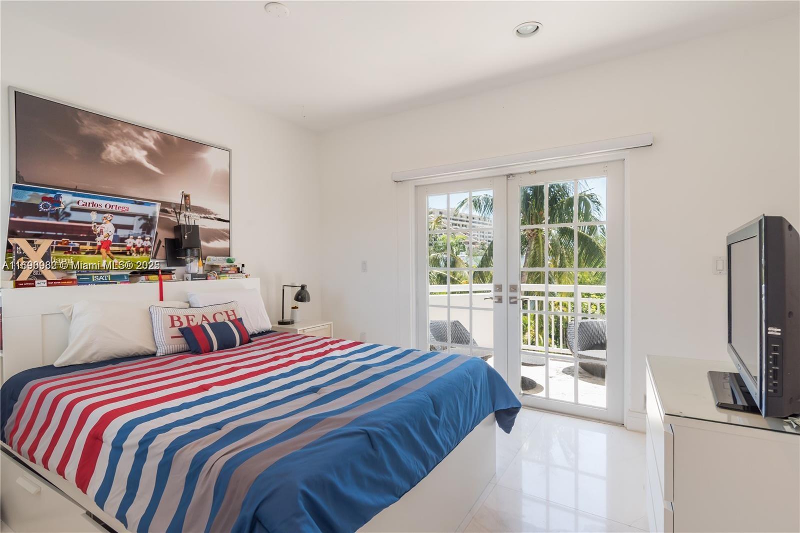 325 Pacific Road Key Biscayne, FL 33149 - Photo 15 of 31 a bedroom with a bed a television and a large window