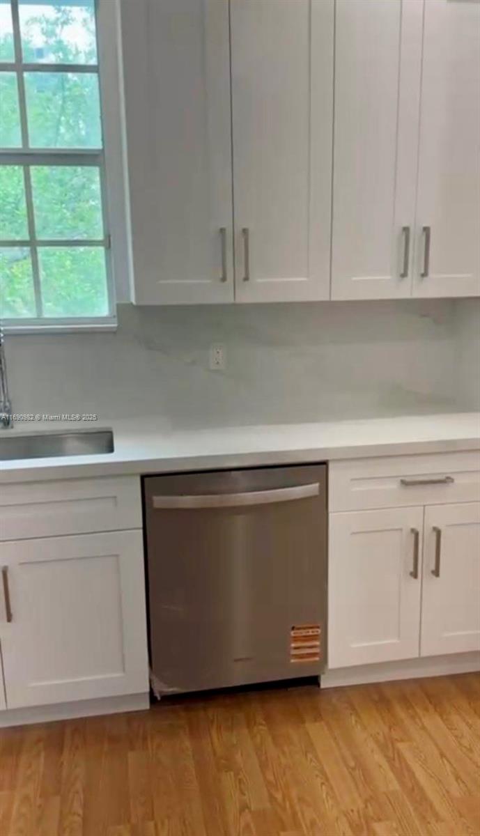 325 Pacific Road Key Biscayne, FL 33149 - Photo 27 of 31 a kitchen with white cabinets and a wooden floor