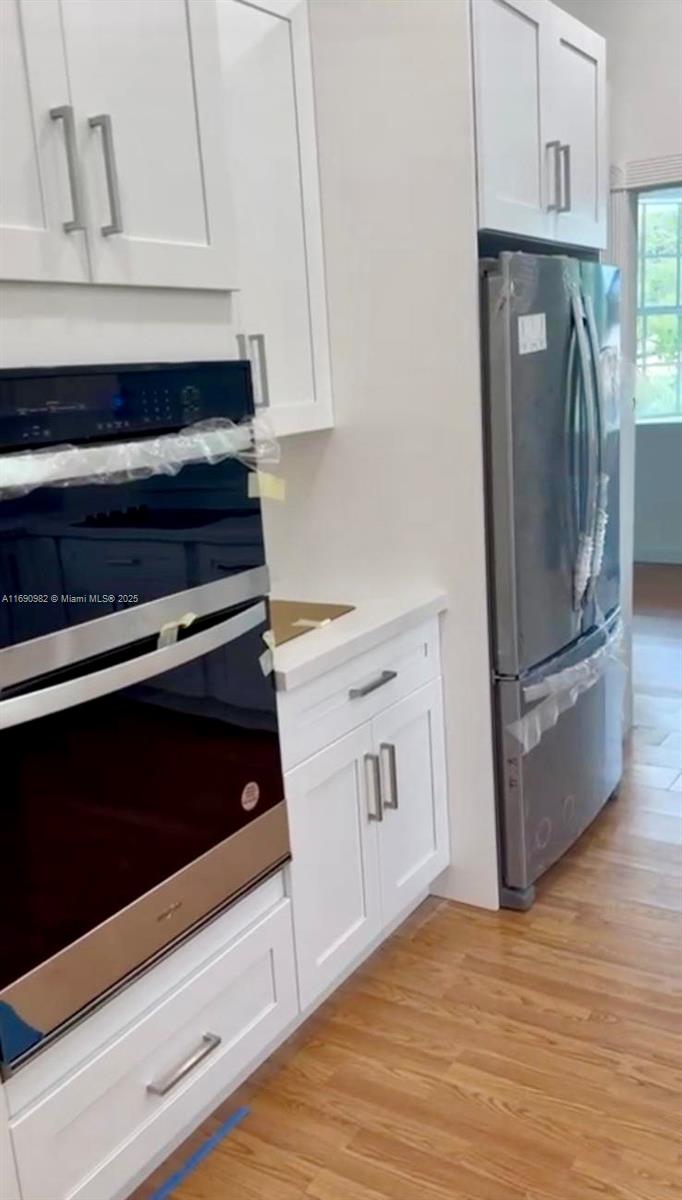 325 Pacific Road Key Biscayne, FL 33149 - Photo 28 of 31 a kitchen with granite countertop white cabinets and stainless steel appliances