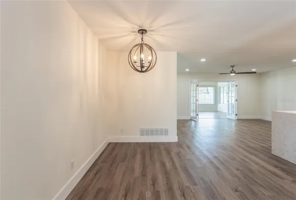 a view of empty room with wooden floor and window