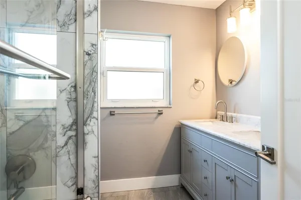a bathroom with a granite countertop sink toilet and a mirror