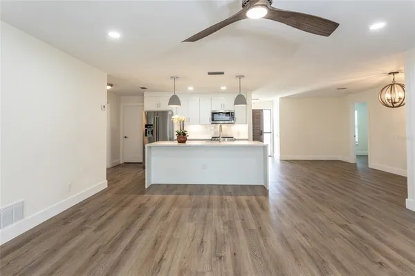 a view of a kitchen with wooden floor and windows