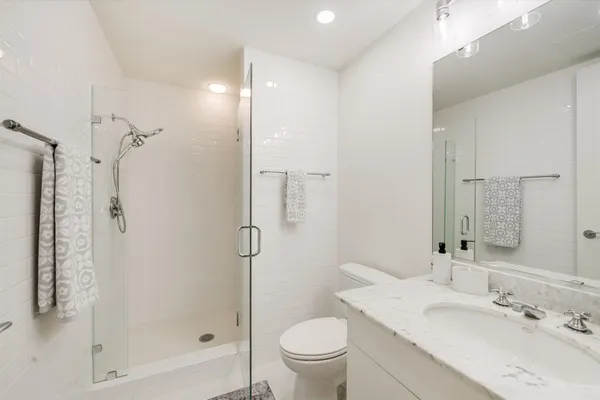 a bathroom with a sink a toilet and shower