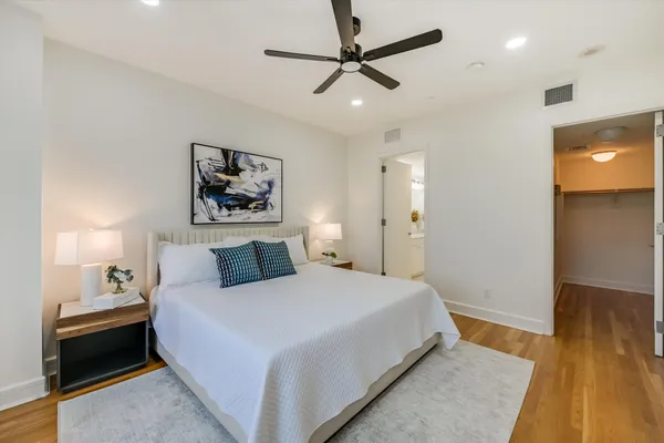 a bedroom with a large bed and a chandelier