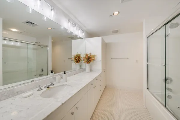 a spacious bathroom with a double vanity sink mirror and shower
