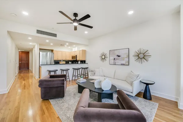a living room with furniture and a wooden floor