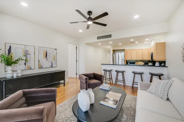 a living room with furniture kitchen view and a potted plant