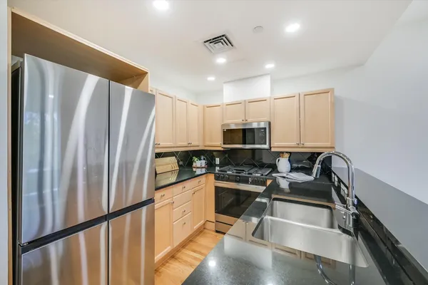 a kitchen with stainless steel appliances a refrigerator and a stove top oven