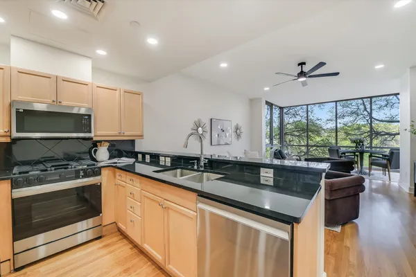 a kitchen with granite countertop a sink stainless steel appliances and cabinets