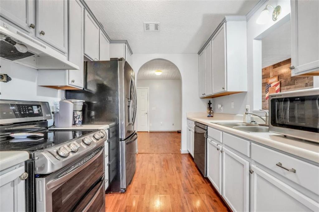 15 Tara Way Covington, GA 30016 - Photo 15 of 40 a kitchen with stainless steel appliances granite countertop a stove a sink and a refrigerator