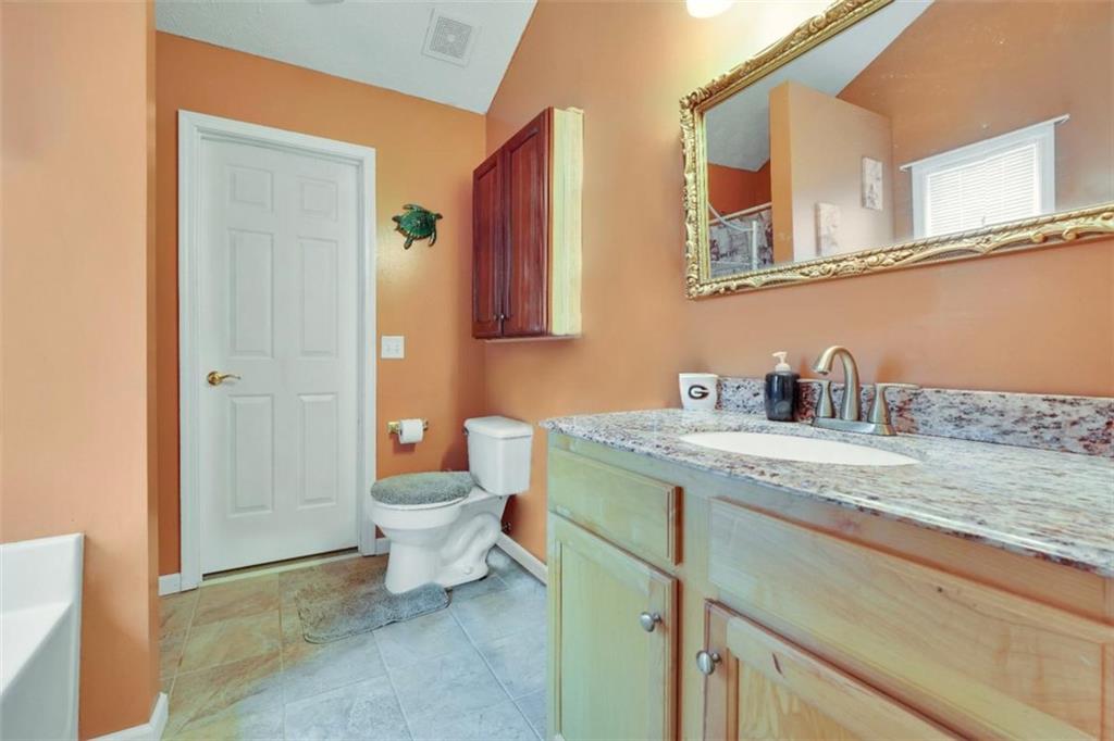 15 Tara Way Covington, GA 30016 - Photo 23 of 40 a bathroom with a granite countertop sink a toilet and a shower