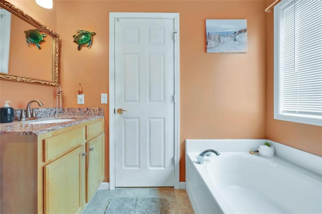 15 Tara Way Covington, GA 30016 - Photo 24 of 40 a bathroom with a tub sink and mirror