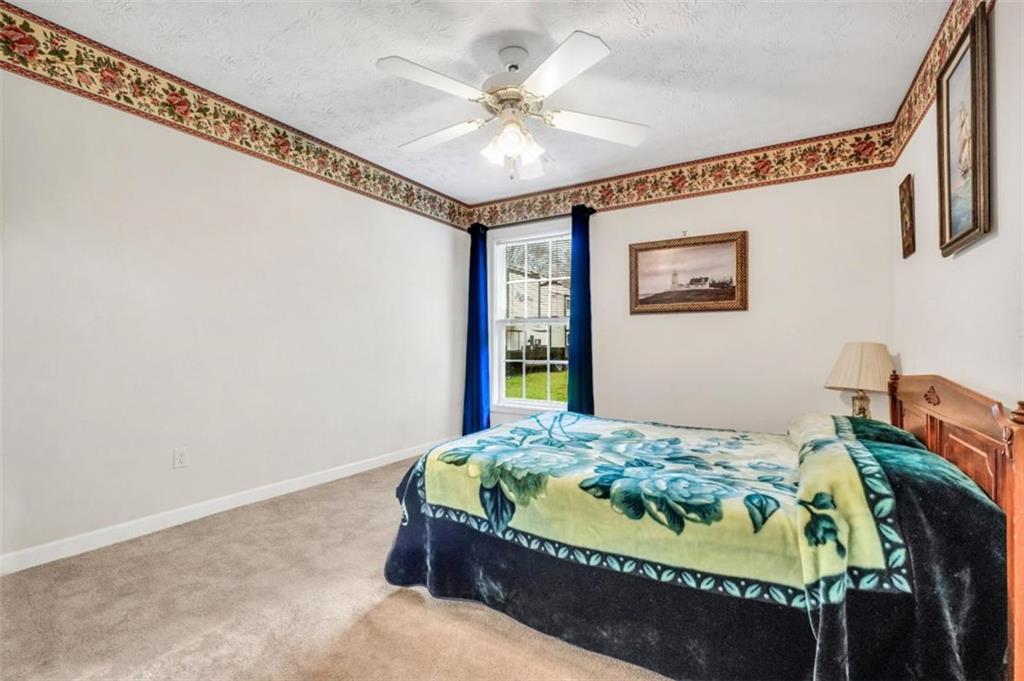 15 Tara Way Covington, GA 30016 - Photo 26 of 40 a bed sitting in a bedroom next to a window
