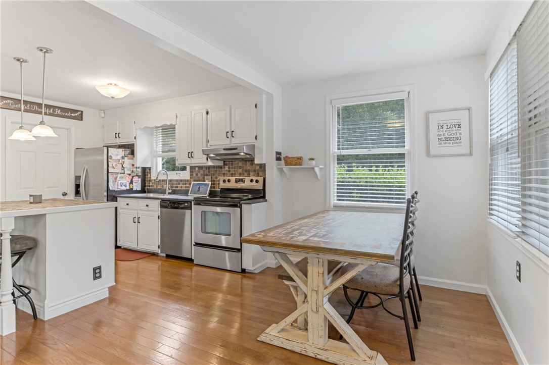 404 Davis Road Liberty, SC 29657 - Photo 11 of 39 A well-lit kitchen with warm wood floors extends into a cozy dining nook.