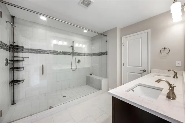 a bathroom with a sink shower and a mirror
