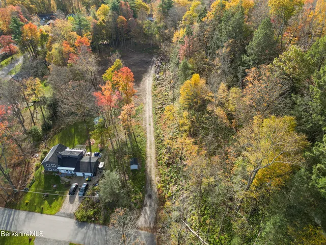 a backyard of a house with table and chairs and wooden fence