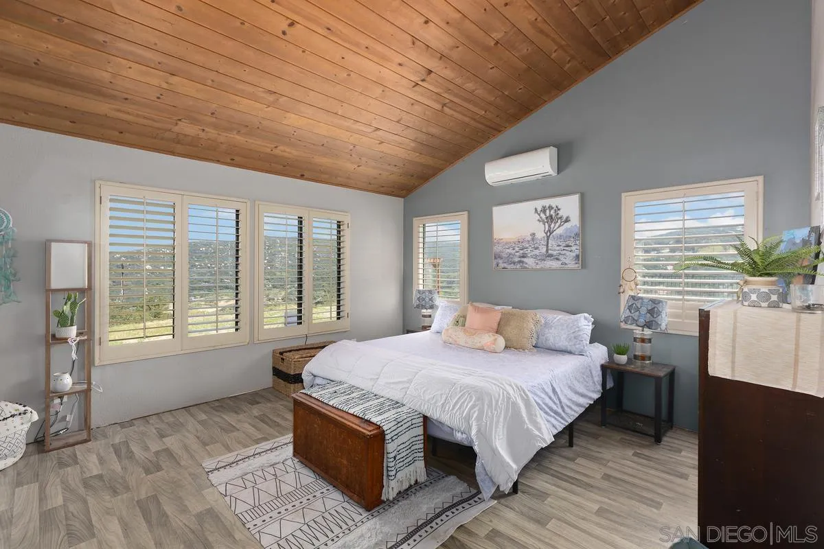 3245 Skytrail Ranch Road Jamul, CA 91935 - Photo 11 of 45 a bedroom with a large bed and a large window