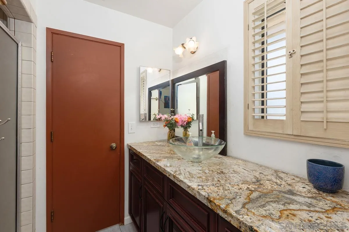 3245 Skytrail Ranch Road Jamul, CA 91935 - Photo 22 of 45 a bathroom with a granite countertop sink and a mirror