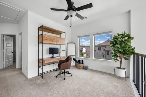 a view of a workspace with furniture and a window