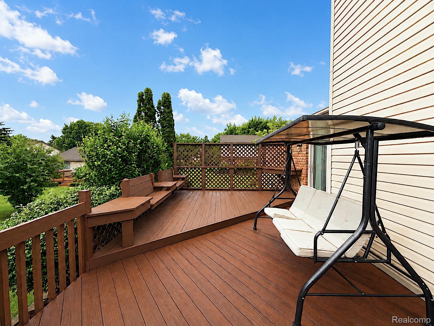 2033 Avonstoke Road Rochester, MI 48307 - Photo 26 of 27 Expansive wood-finish deck featuring integrated bench seating and lattice privacy screens