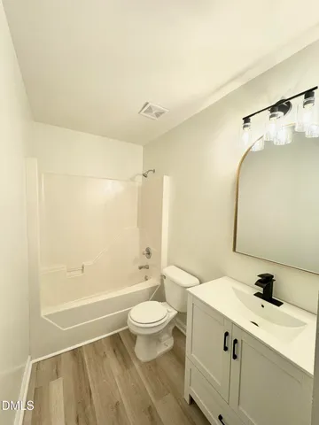 a bathroom with a granite countertop sink a toilet and shower