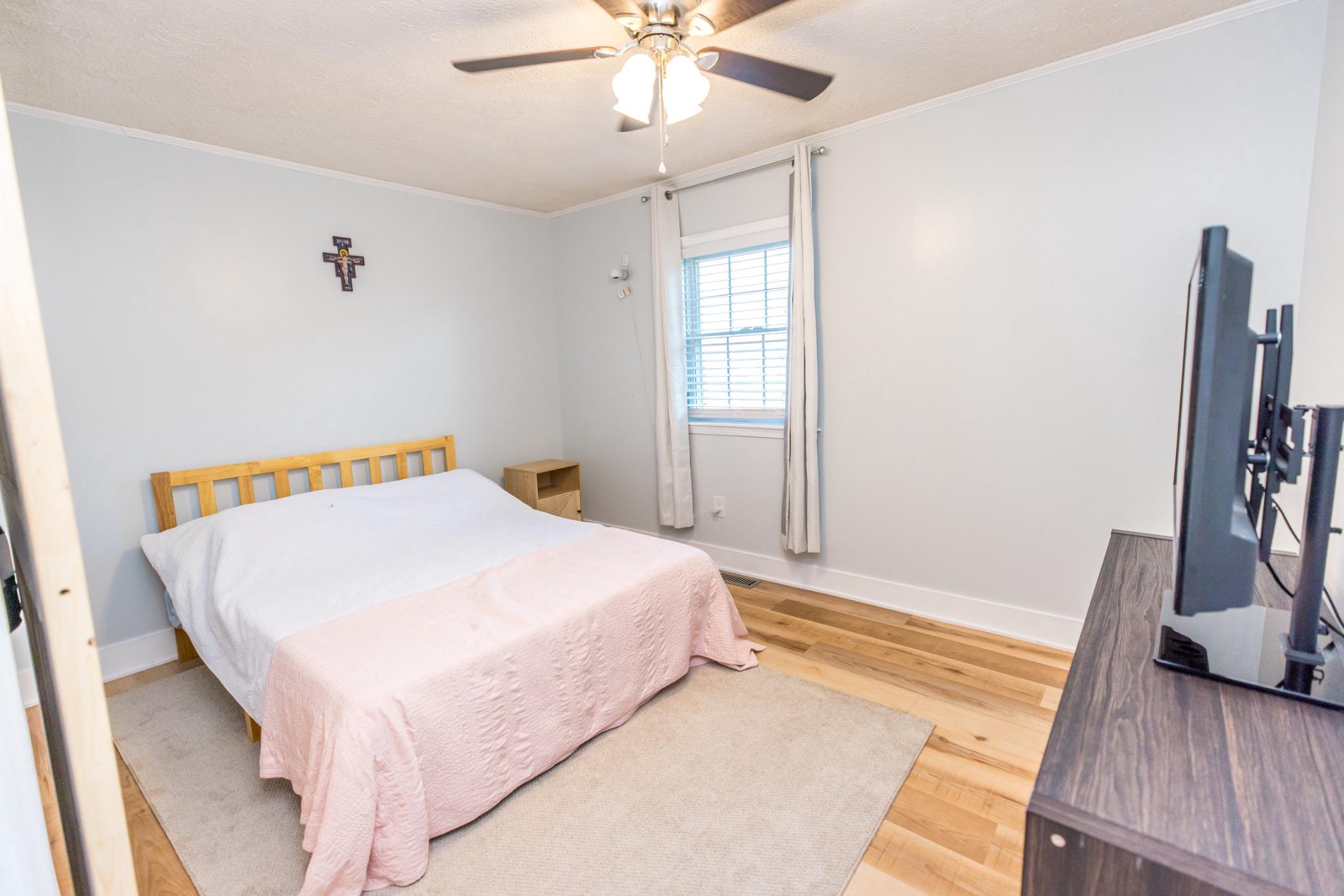3427 York Street Manchester, MD 21102 - Photo 10 of 26 a bedroom with a bed and a flat tv screen on dresser