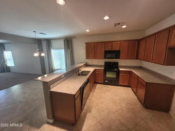 a kitchen with stainless steel appliances granite countertop a stove a sink and a refrigerator