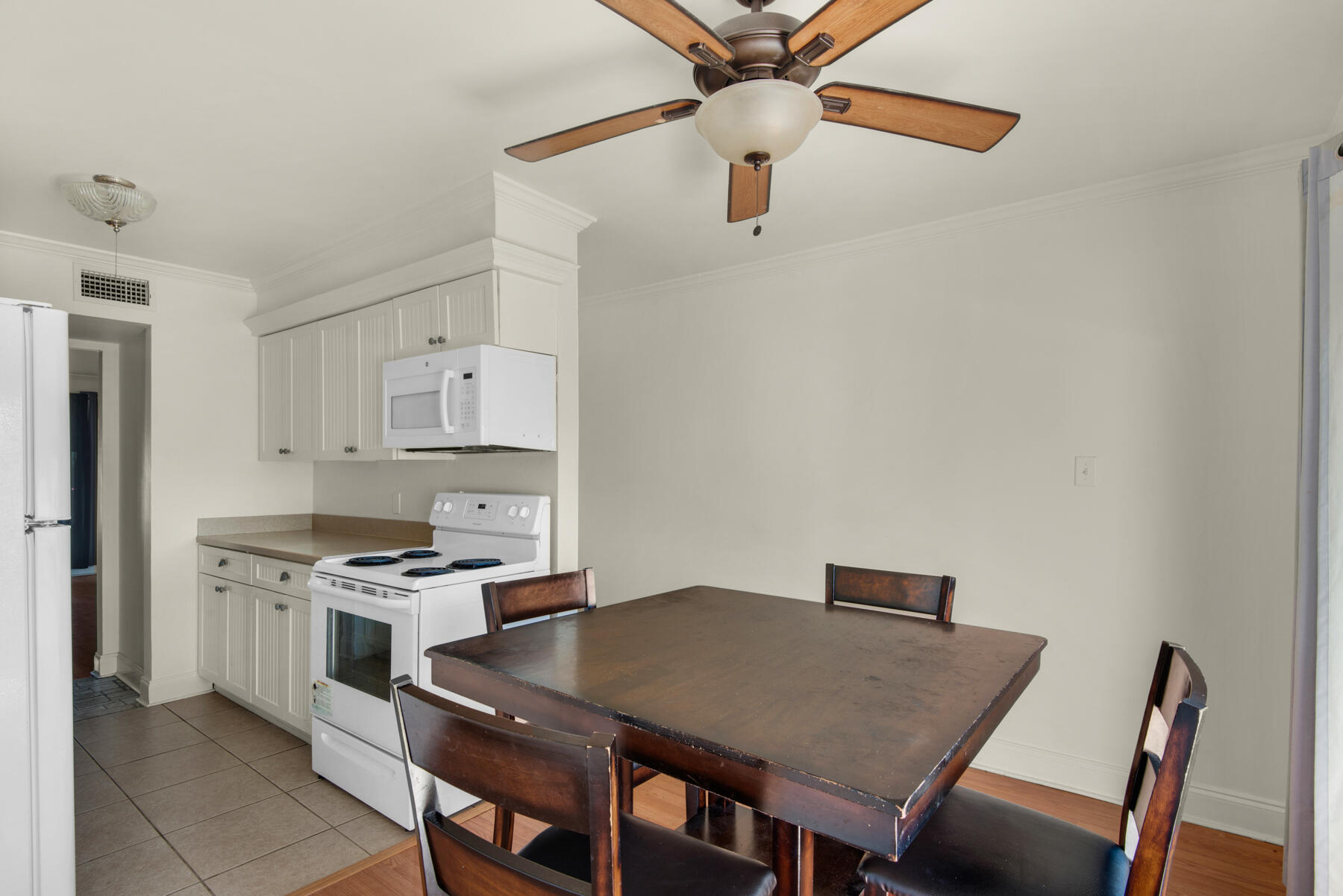 210 Pelham Road, Unit 215B Fort Walton Beach, FL 32547 - Photo 6 of 22 a kitchen with stainless steel appliances stove top oven table and chairs