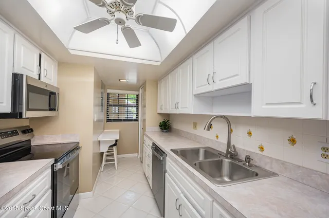 a kitchen with stainless steel appliances granite countertop a sink a stove and a microwave oven with cabinets