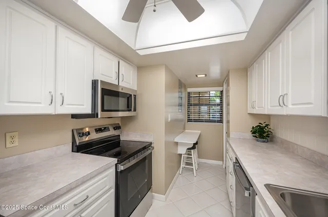 a kitchen with stainless steel appliances granite countertop a sink stove and microwave