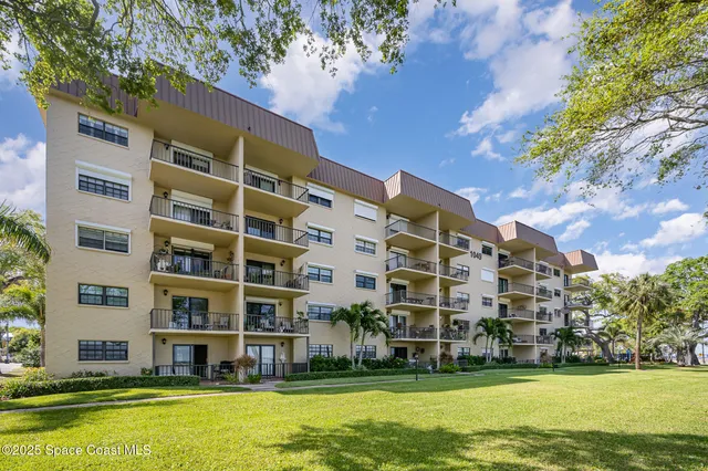 a front view of a building with a garden and swimming pool