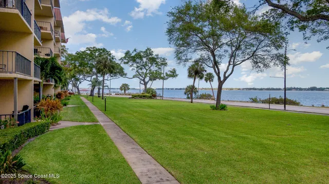 an aerial view of a residential houses with outdoor space and ocean view