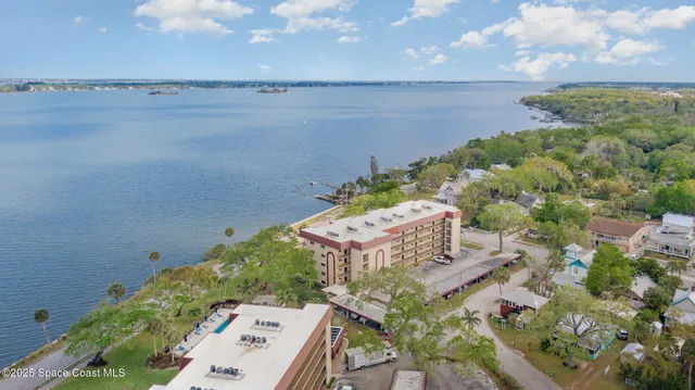 an aerial view of a house with a yard and lake view in back