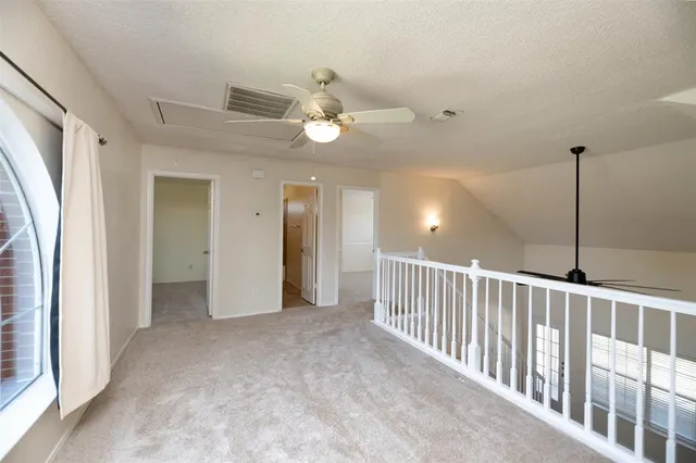 a view of a hallway with a ceiling fan and window