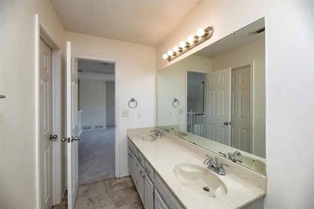 a bathroom with a sink shower and a mirror