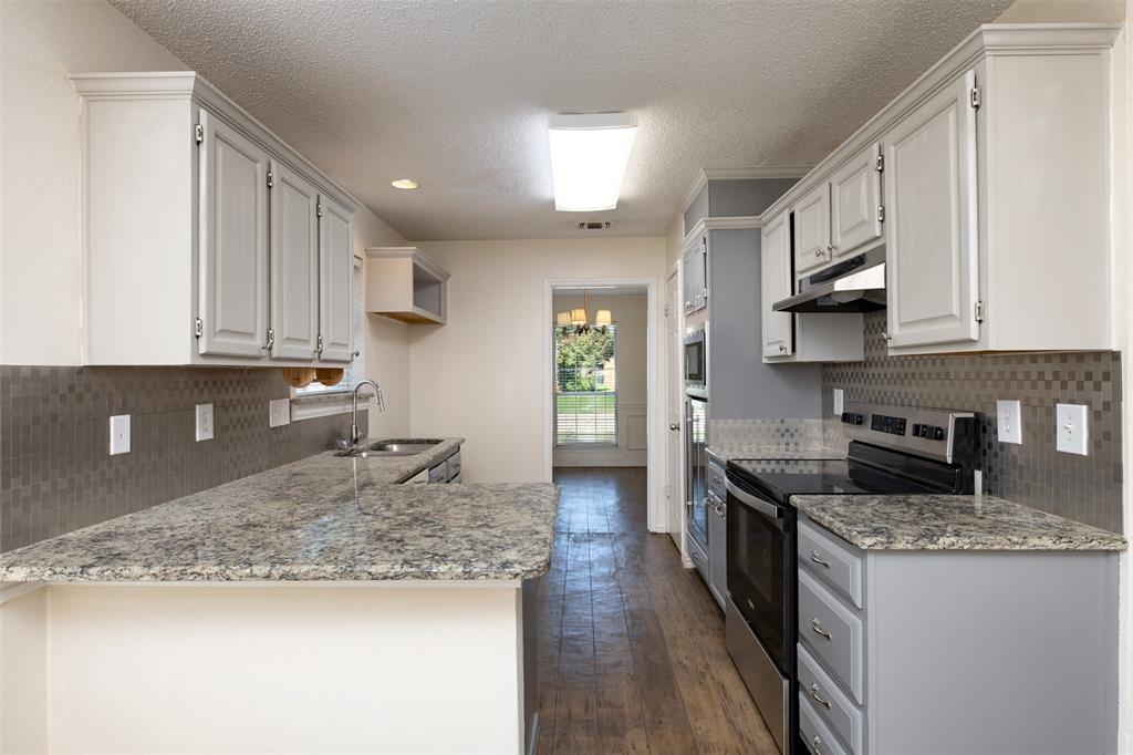 1410 Brookside Drive Allen, TX 75002 - Photo 6 of 38 a kitchen with granite countertop a sink a stove top oven a counter space and cabinets