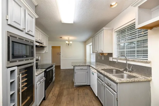 a kitchen with stainless steel appliances granite countertop a sink and a stove
