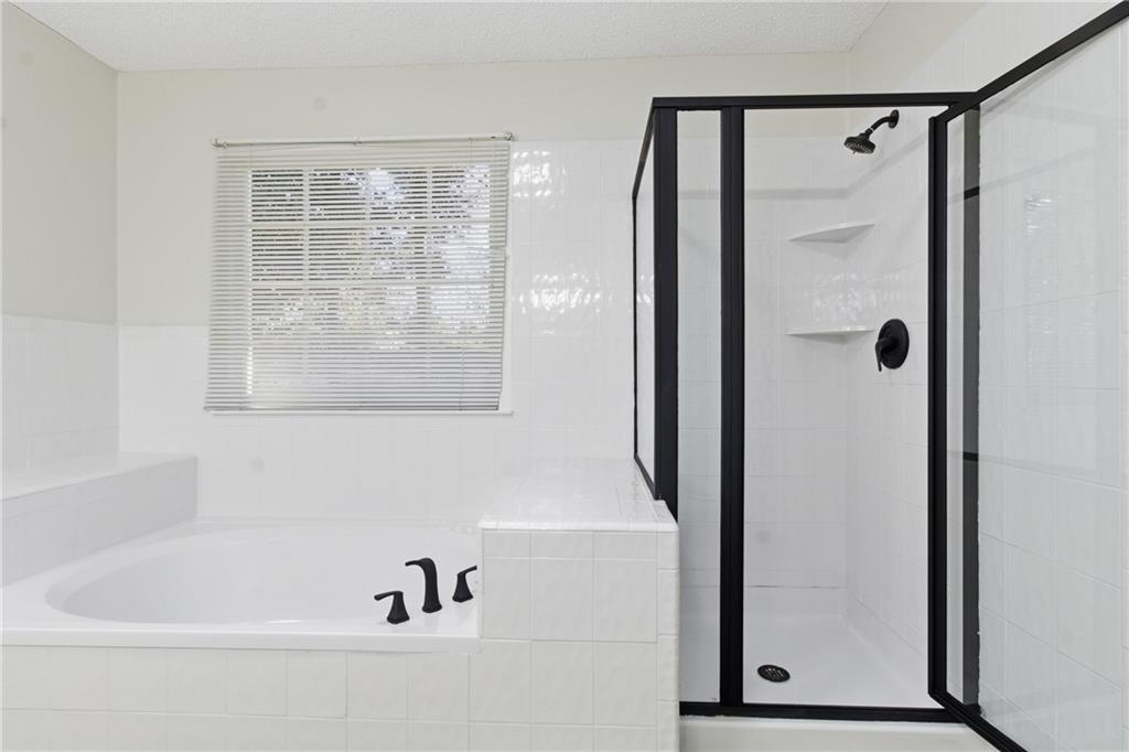 2110 Meadow View Court Grayson, GA 30017 - Photo 35 of 50 a bathroom with a bathtub and a shower