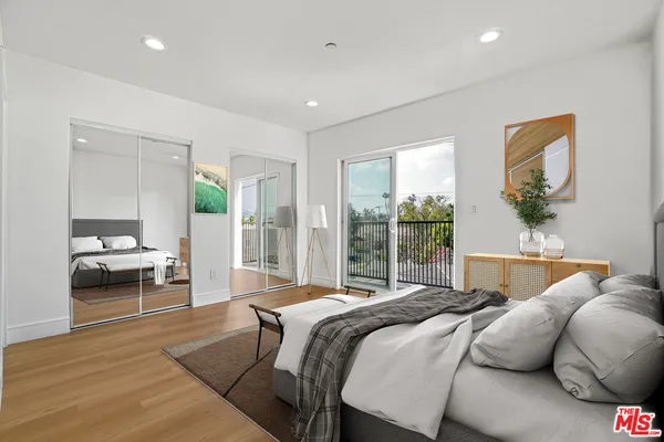 a view of kitchen with stainless steel appliances kitchen island wooden floor and living room view