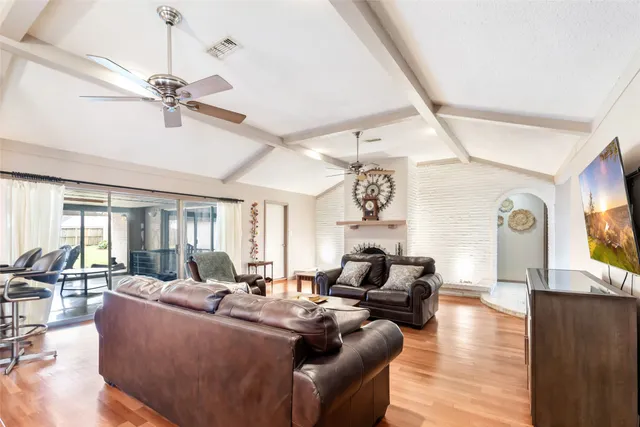 a view of a dining room and livingroom with furniture wooden floor a chandelier