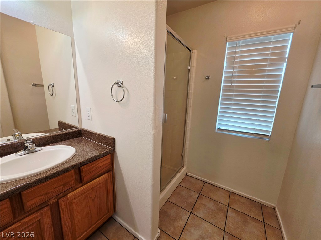 1571 Rusty Ridge Lane Henderson, NV 89002 - Photo 17 of 26 A well-appointed bathroom offers a single vanity with ample counter space and a convenient shower enclosure.