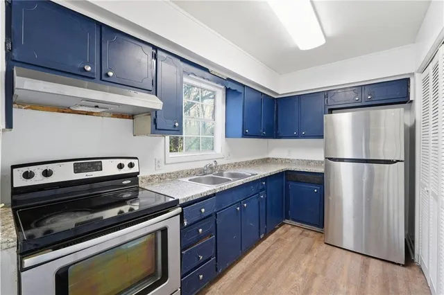 a kitchen with a refrigerator sink and cabinets