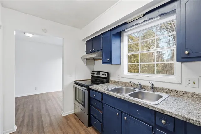 a kitchen with stainless steel appliances granite countertop a sink stove and cabinets