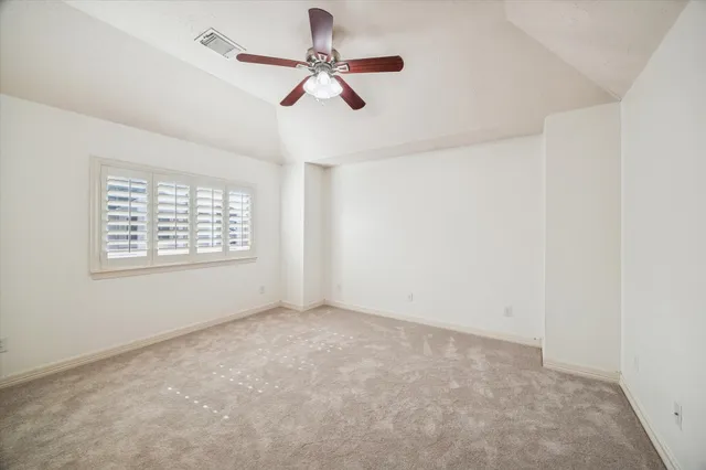 an empty room with a window and a fan