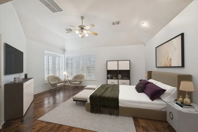 a bedroom with a bed a couch and a flat screen tv