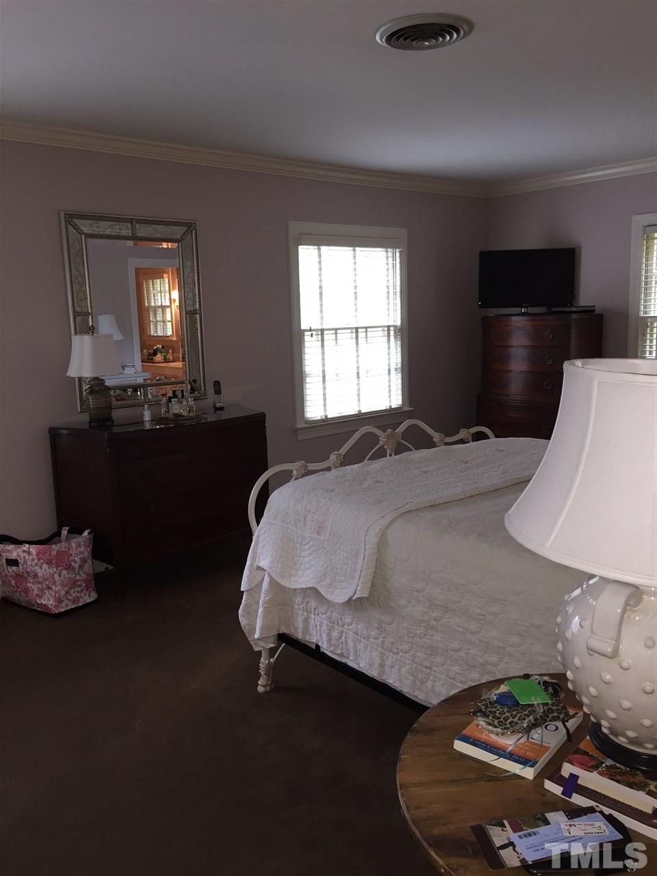 910 Blenheim Drive Raleigh, NC 27612 - Photo 8 of 11 a bedroom with a bed and window