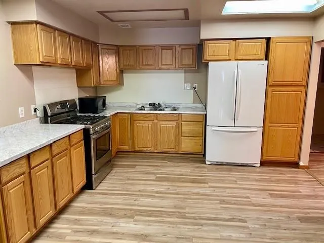 a kitchen with granite countertop a refrigerator stove top oven and sink