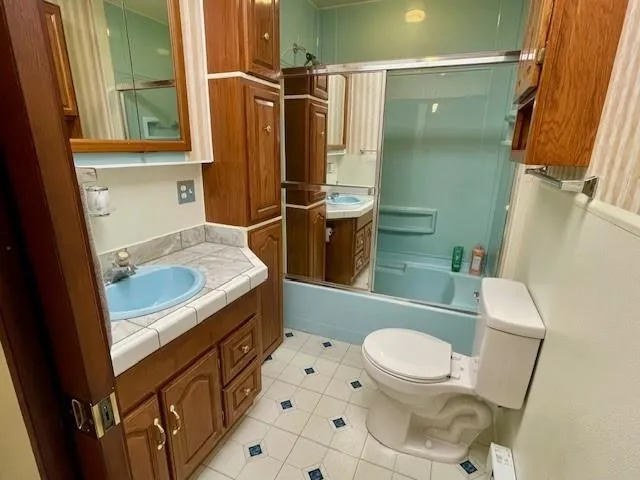 a bathroom with a sink a toilet a mirror and shower