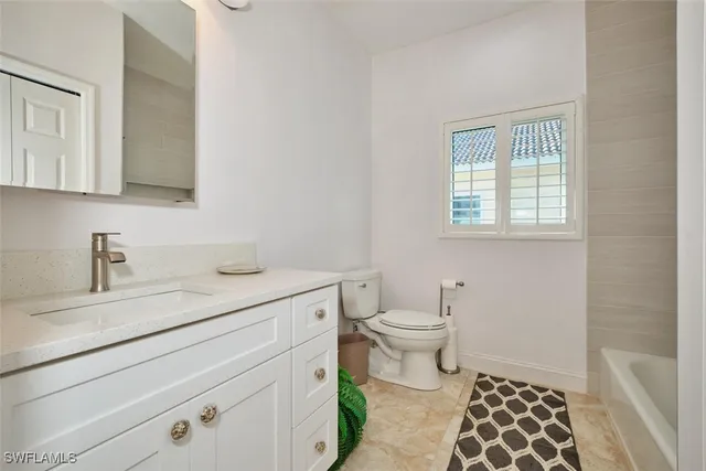 a bath room with a toilet a sink and a bath tub