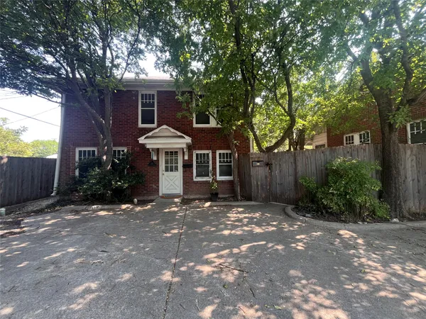 a front view of a house with a yard and potted plants